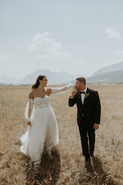husband kissing wife's hand during elopement photos in montana