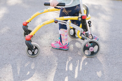 Child walking with a Gait Trainer Device, a pediatric solution designed to assist children with mobility impairment.