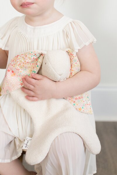 photo of little girl holding bunny by the ear