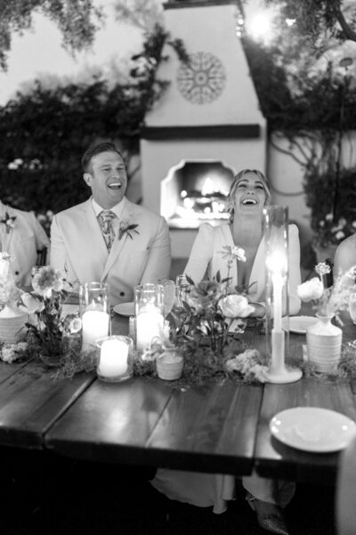 Bride and groom laughing together during candlelit reception at El Chorro.