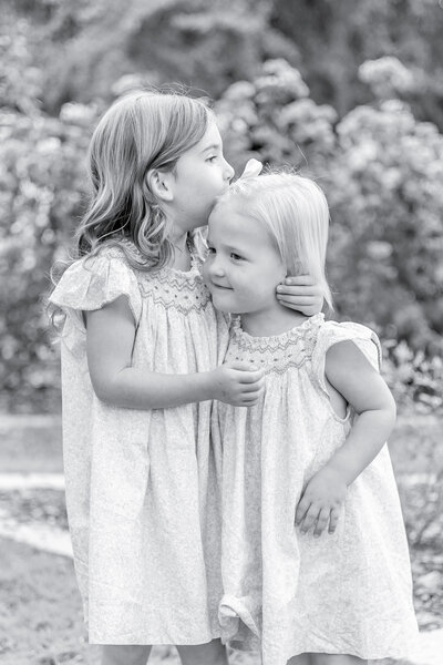 A mother embraces her young son on a wooden bench, sharing a sweet and joyful moment outdoors. Their laughter and closeness capture the warmth of family bonds, reflecting the natural and heartfelt style of Birmingham family photography.
