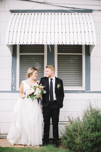 Bride and groom posing in front of a building