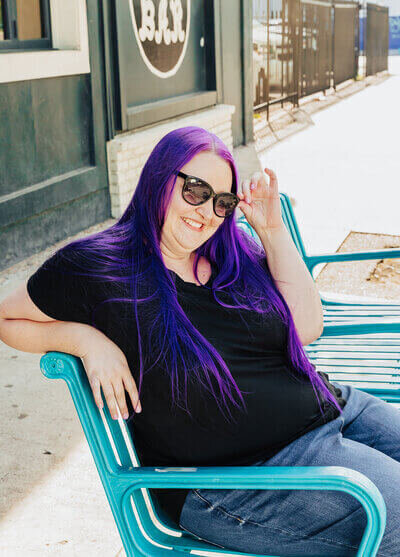 Heidi Thompson sitting on a blue bench in San Diego, CA.