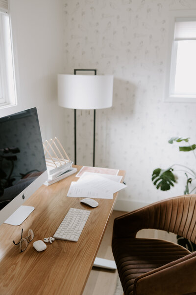 An empty desk with an iMac and website copywriting printouts on it