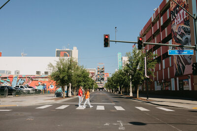 Two people walking across a crosswalk.