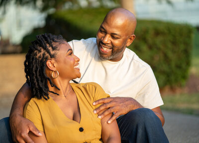 An African-American couple smile at each other.