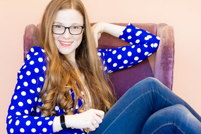 headshot of Erika Cockerham-the owner of Erika Rene Photography- smiling, wearing blue and white polka dots
