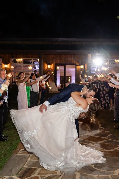 Groom dips his bride in wedding sparkler send-off