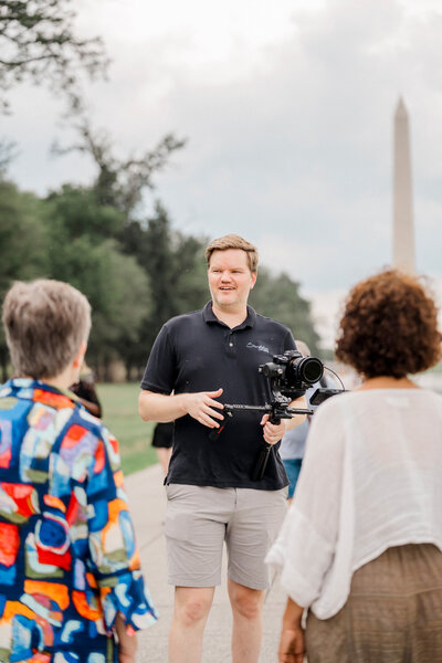 a video producer directs talent while operating a camera gimbal