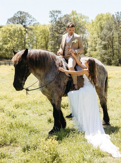 A bride and groom on horseback on their wedding day.