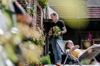 A girl resting on her chair and her father gardening