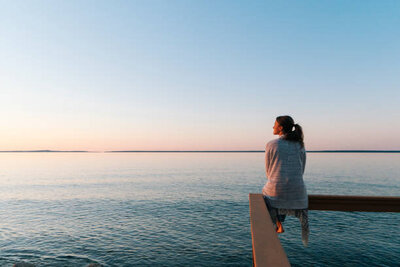 A women looking out at the ocean in deep thought.