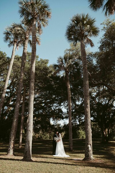 Bride and groom at Amelia River Club at sunset with a vintage car.