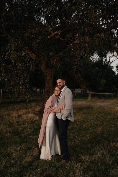 bride and groom cuddling during their sunset photos in Mount Macedon
