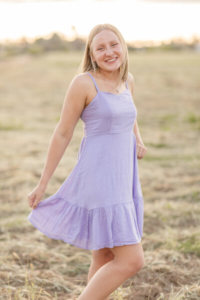 a girl posing in front of a barn