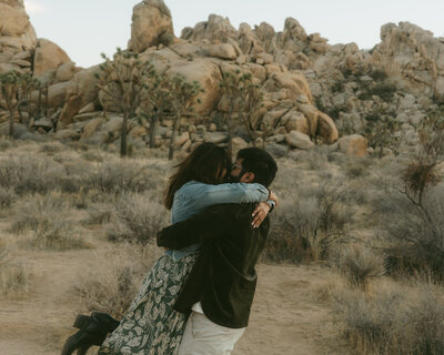 Couple hugging among Joshua Trees during their intimate desert elopement