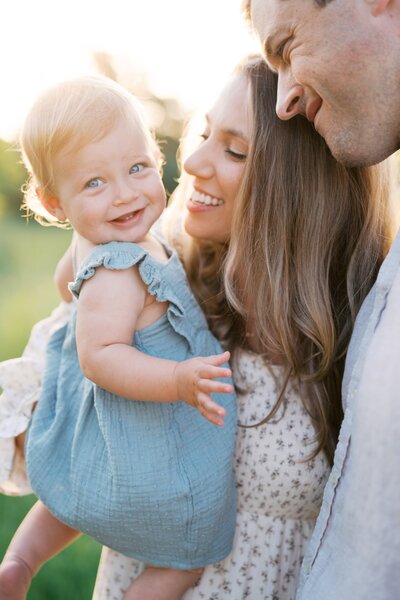 A mother and her girls stop to smell the flowers, while dad and baby brother watch from afar.