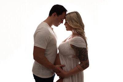Atlanta, Georgia newborn photographer portrait session with pregnant woman at maternity session posing with husband facing eachother