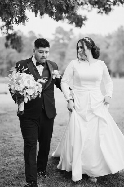 Bride and groom walking hand in hand towards camera