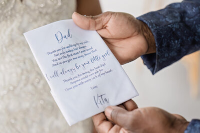 Groom holding a beautifully designed wedding vow card before the ceremony.