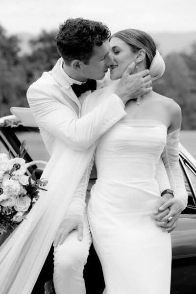 black and white photo of bride and groom  kissing