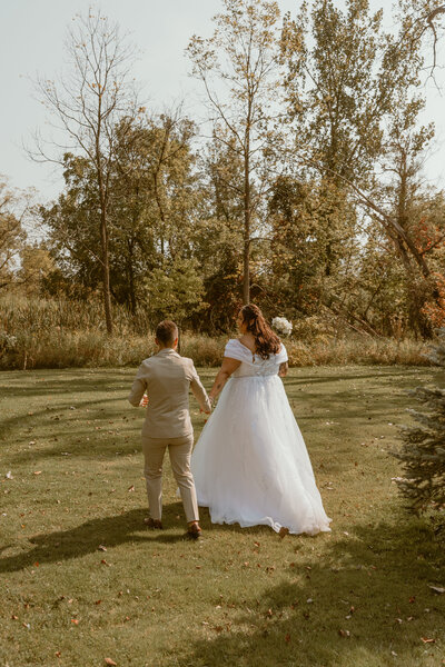 photo of two brides walking in a field