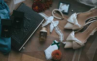 A flat lay of jewelry, shoes and other details from a wedding, representing an example of full service wedding planning inspiration. 