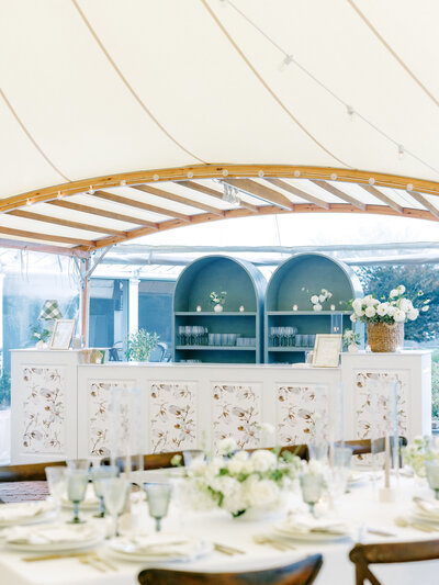 Wedding reception bar decorated with florals and blue shelves