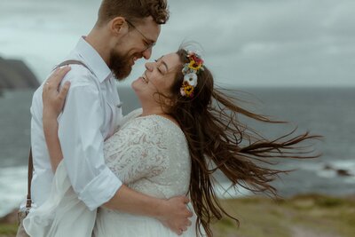 bride and groom laugh by the ocean during their Newfoundland elopement