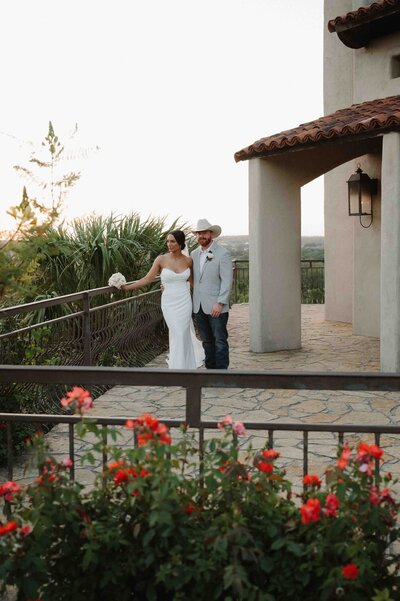 During golden hour, bride and groom poses behind Chapel Dulcinea