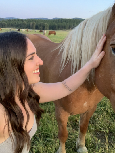Mikaela Kahn petting a horse