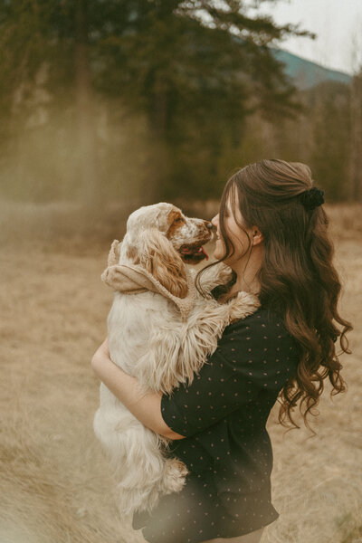 girl with long hair holding an english cocker spaniel