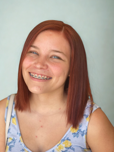 Stylist curling client’s highlighted hair with a professional curling iron in salon setting.
