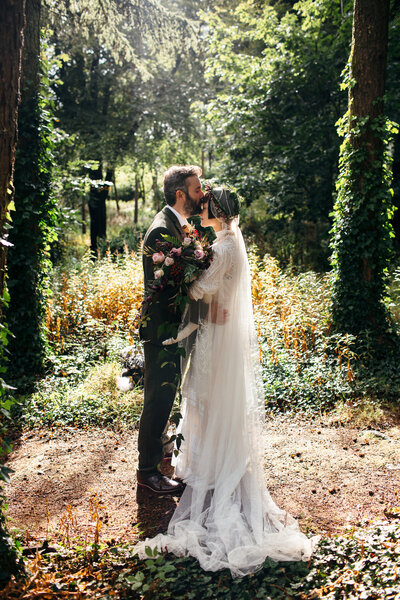 Romantic and unique backlit wedding photo taken in the woods at Coombe Trenchard in Devon 