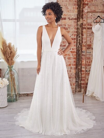 Boho A-Line Wedding Dress.  Looking to show off your shoulders and collarbones? This boho A-line wedding dress features a plunging V-neckline and lacy straps to help you do just that.