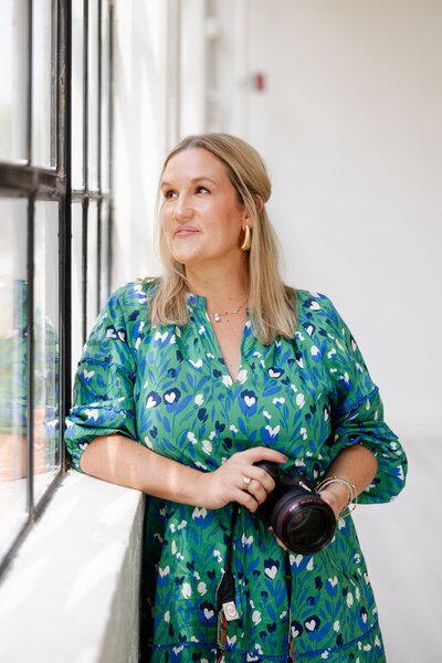 woman holds a camera up to her eye