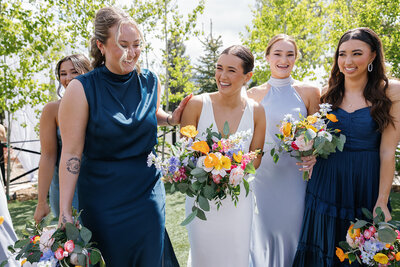 bride in a vintage inspired gown with a colorful bouquet in her hand as she walks through her wedding venue in texas.