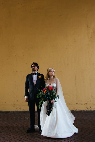 Hipster Bride and Groom posing for portraits under an overpass