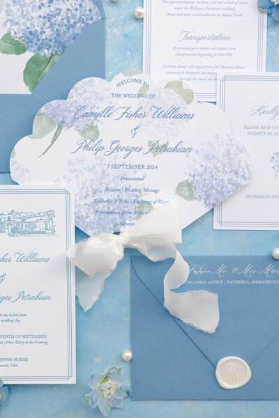 Blue and white custom wedding invitations with hydrangea design, wax seal, and luxury stationery.