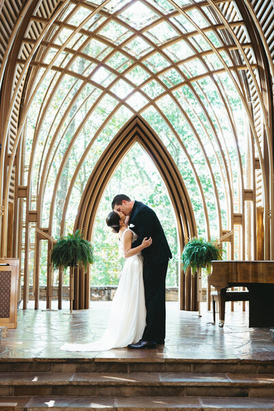 Joyful wedding day kiss at bella vista chapel in Arkansas, included in Joy and Light Photography wedding client testimonials.