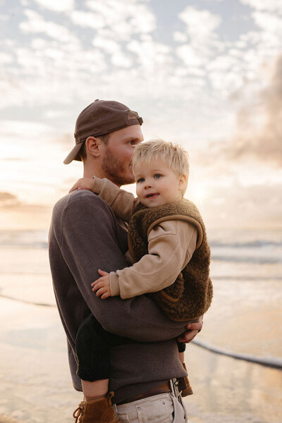 Papa en zoontje tijdens gezinsshoot op het strand