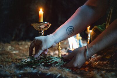 A close up shot of Rachael Maddox's hands as she performs a sacred ceremony outside as part of her sales page writing ritual.