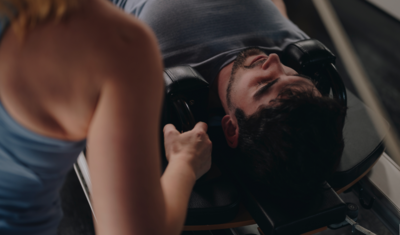 woman assisting a client on a Pilates reformer 