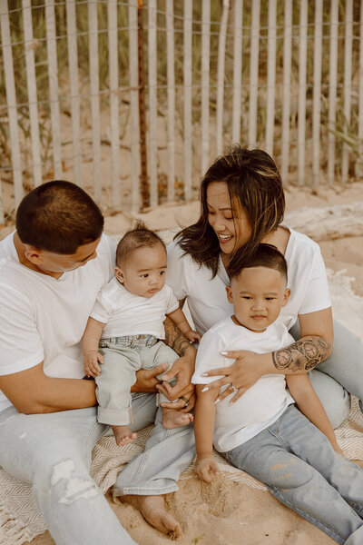 Young Family cuddles together in field