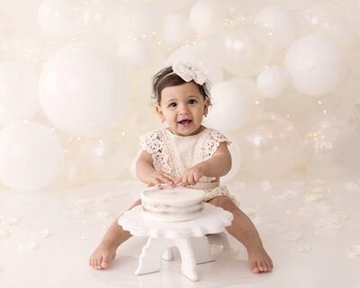 White balloons in a cake smash from Akron baby photographer Mary Christine