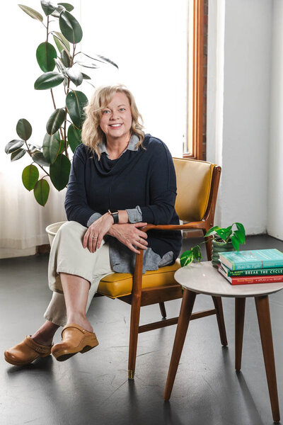 Lori Lubbers in a chair with books