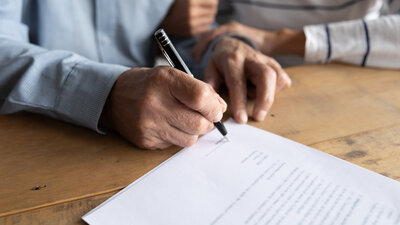 Man writing on a piece of paper for financial and retirement services