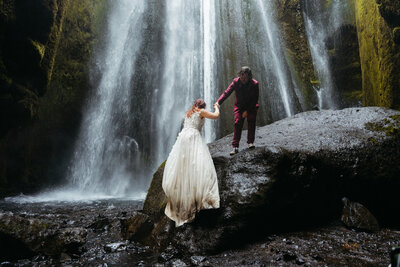 Couple having a snowball fight on their wedding day at their winter wedding in the Dolomites Italy