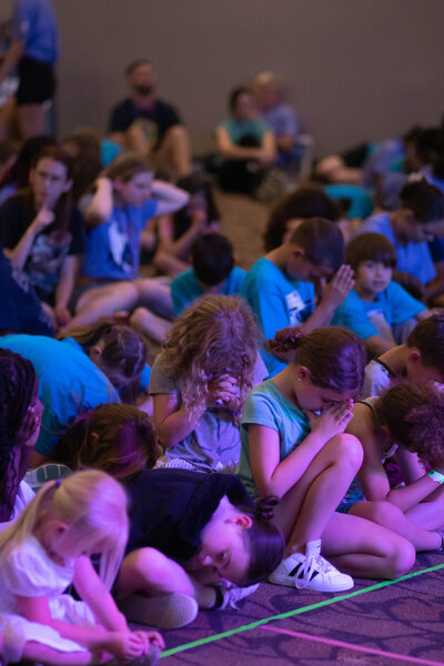 Group of kids praying at Vacation Bible School at a non-denominational church in Fayetteville, NC.