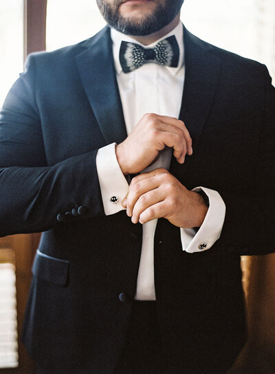 Classic black groom tux with a black and white Brackish bow tie